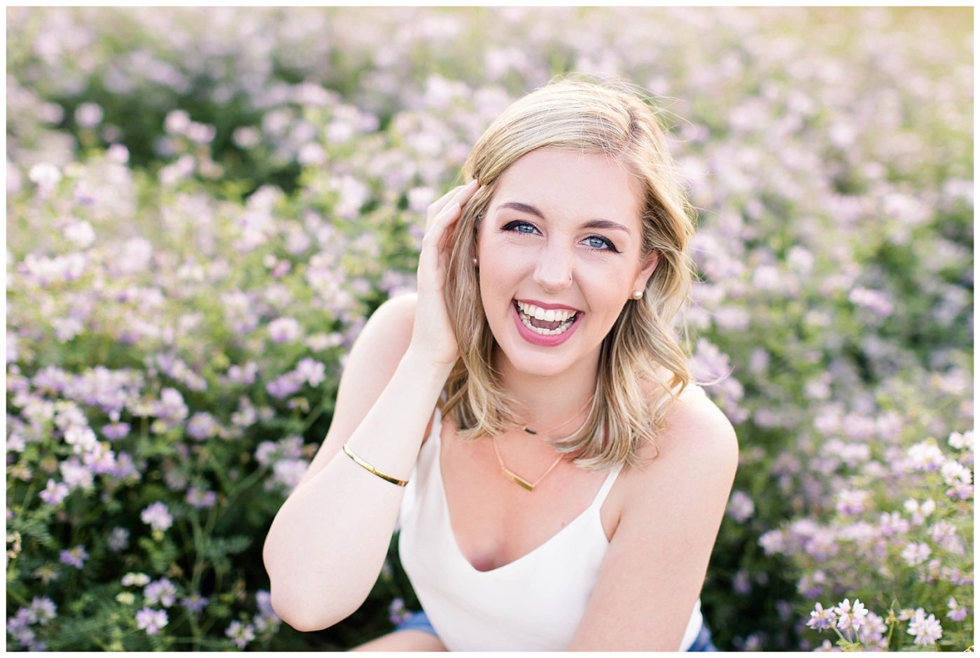Joyful portrait of Abby Sheehan Laughing while looking at the camera in a field of wildflowers 