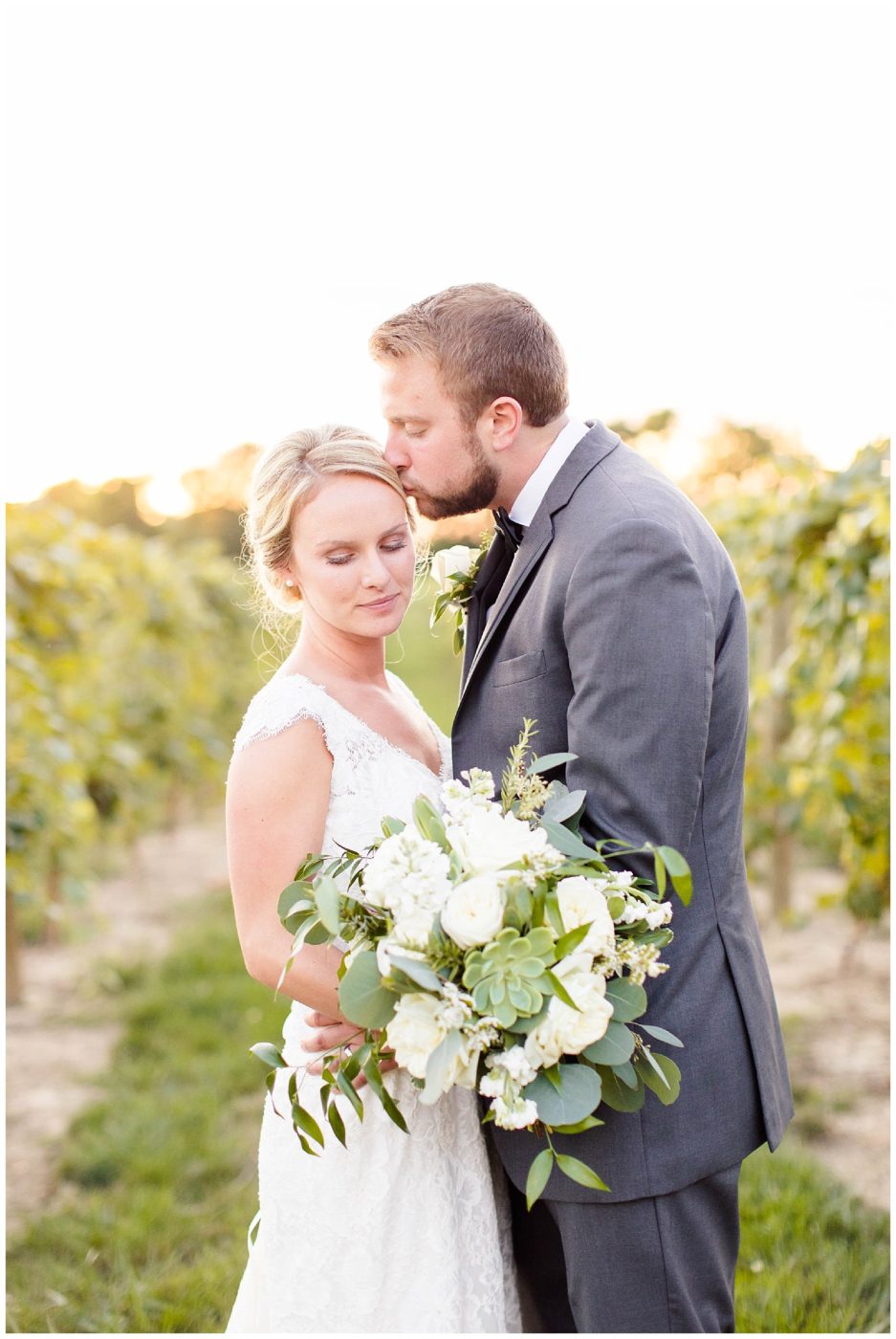 Gorgeous bride and groom standing in the middle of the beautiful vineyard at sunset 